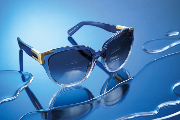 Original test image of sunglasses on a reflective blue surface with water puddles